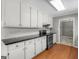 Bright kitchen features white cabinetry, stainless appliances, and wood floors at 1190 N Ola Rd, Mcdonough, GA 30252