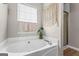 Large, luxurious bathtub adjacent to glass-enclosed shower offers the perfect place to relax at 161 Mills Dr, Covington, GA 30016