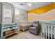 Cozy Bedroom features pastel colors, 2 cribs, comfy chair and changing table at 161 Mills Dr, Covington, GA 30016