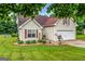 Beautifully landscaped home with vibrant green lawn, mature trees, and charming curb appeal at 161 Mills Dr, Covington, GA 30016