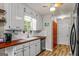 Well-lit kitchen featuring white cabinets, wood countertops, stainless steel appliances, and hardwood floors at 161 Mills Dr, Covington, GA 30016