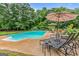 Relaxing poolside view with lounge chairs, patio umbrella, and a tranquil tree lined backdrop at 161 Mills Dr, Covington, GA 30016