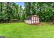 A shed in the backyard on a flat, well-maintained lawn, offering ample storage and functionality on the property at 161 Mills Dr, Covington, GA 30016