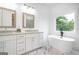 Bright bathroom with double vanity, modern freestanding tub, white cabinets, and beautiful marble floors at 1993 Reynolds Sw Dr, Atlanta, GA 30315