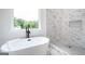 Modern bathroom featuring a soaking tub with black hardware and marble tile shower with built-in niche at 1993 Reynolds Sw Dr, Atlanta, GA 30315