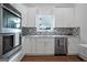 Modern kitchen with stainless steel appliances, white cabinets, undermount sink, and mosaic tile backsplash at 1993 Reynolds Sw Dr, Atlanta, GA 30315