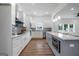 Open-concept kitchen with island, stainless appliances, white cabinets, mosaic backsplash and modern pendant lighting at 1993 Reynolds Sw Dr, Atlanta, GA 30315