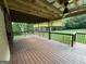 View of the spacious wooden deck with ceiling fan and wooded backyard at 5761 Hancock Dr, Social Circle, GA 30025