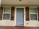 Front door with gray paint and wood-look shutters on either side of the windows at 5761 Hancock Dr, Social Circle, GA 30025