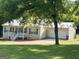 Single-story home with metal roof, covered porch, attached garage, and driveway surrounded by trees and grass at 5761 Hancock Dr, Social Circle, GA 30025