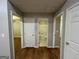 Hallway featuring hardwood floors with access to three rooms and a bathroom with a bathtub at 5761 Hancock Dr, Social Circle, GA 30025