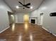 Open living room with hardwood floors, ceiling fan, a fireplace, and natural light at 5761 Hancock Dr, Social Circle, GA 30025