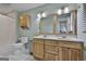 Bathroom with double sinks, shower with tile surround, and wood cabinets at 125 Drennan Dr, Fayetteville, GA 30215
