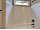 Clean and functional bathroom featuring a white shower tub combo, bronze fixtures, and a window for ventilation at 473 Cherry Creek Dr, Loganville, GA 30052