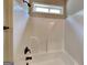 Well-maintained bathroom showcasing a white shower tub combo, bronze fixtures, and a window for ventilation at 473 Cherry Creek Dr, Loganville, GA 30052