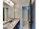Bathroom vanity featuring a granite countertop, white sink, large mirror and modern lighting at 473 Cherry Creek Dr, Loganville, GA 30052