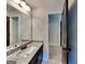 Modern bathroom with granite vanity, dark wood cabinetry, a framed mirror, and a separate doorway at 473 Cherry Creek Dr, Loganville, GA 30052