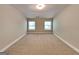Bright bedroom with neutral carpeting and two windows, providing a serene and comfortable living space at 473 Cherry Creek Dr, Loganville, GA 30052