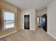 Bedroom showcasing a neutral carpet, large window letting in natural light, and a dark wooden door at 473 Cherry Creek Dr, Loganville, GA 30052