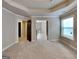 Spacious bedroom with neutral carpet, tray ceiling, and doorways to other rooms at 473 Cherry Creek Dr, Loganville, GA 30052