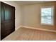 This bedroom features a neutral color scheme, a window letting in natural light and a wooden door at 473 Cherry Creek Dr, Loganville, GA 30052