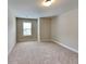 Bedroom featuring a neutral carpet, large window letting in natural light, and tan colored walls at 473 Cherry Creek Dr, Loganville, GA 30052