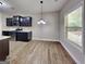Contemporary kitchen with dark cabinets, stainless steel appliances, and durable vinyl flooring, illuminated by natural light at 473 Cherry Creek Dr, Loganville, GA 30052