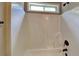 Shower tub with a white surround, bronze fixtures, and a small window for natural light at 473 Cherry Creek Dr, Loganville, GA 30052