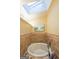 Relaxing bathroom with a skylight and a separate tub with unique tile surround at 295 Pinehurst Dr, Stockbridge, GA 30281