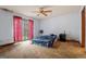 A bedroom with a ceiling fan, curtains, sliding glass door and unvarnished plywood floor at 655 Sunset Dr, Locust Grove, GA 30248