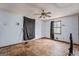 A bedroom with a ceiling fan, and a window with black out curtains, and an unfinished plywood floor at 655 Sunset Dr, Locust Grove, GA 30248