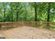 Wooden deck with railings surrounded by lush greenery, perfect for outdoor relaxation at 655 Sunset Dr, Locust Grove, GA 30248