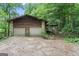 Charming home exterior with a two-car garage, stone accents, and a wooded lot at 655 Sunset Dr, Locust Grove, GA 30248