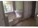 Bathroom featuring a tiled floor, a jetted tub, and a window with natural light at 390 Burg Rd, Locust Grove, GA 30248