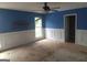 Bedroom with a window, blue and white paneled walls, bare floors and a ceiling fan at 390 Burg Rd, Locust Grove, GA 30248