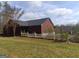 Exterior shot of a single story red brick home with white picket fence in yard at 390 Burg Rd, Locust Grove, GA 30248