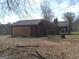 Exterior shot of a home with a red brick finish, featuring a two-car garage with wooden door at 390 Burg Rd, Locust Grove, GA 30248