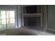 Cozy living room with stone fireplace, built-in shelves, and sliding door access to outdoor deck at 390 Burg Rd, Locust Grove, GA 30248