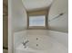 A relaxing, tiled bathtub is featured with a window in this bathroom at 426 Summer Hill Cir, Stockbridge, GA 30281