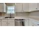 Well-lit kitchen with white cabinets, stainless steel appliances, and a sink overlooking the backyard at 426 Summer Hill Cir, Stockbridge, GA 30281