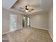 Main bedroom featuring carpeted flooring, two doors, a ceiling fan, and tray ceiling at 426 Summer Hill Cir, Stockbridge, GA 30281