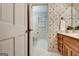 Floral wallpaper accents this bathroom with a white tile floor and vanity at 550 Hawthorne Dr, Fayetteville, GA 30214