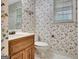 A floral wallpapered bathroom with a toilet and vanity adjacent to a window at 550 Hawthorne Dr, Fayetteville, GA 30214