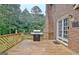 Outdoor deck featuring a grill, wooden railing, brick home and wooded area at 550 Hawthorne Dr, Fayetteville, GA 30214