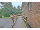 Exterior of brick home featuring a ramp leading to an elevated deck and wooded surroundings at 550 Hawthorne Dr, Fayetteville, GA 30214