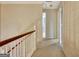 Carpeted upstairs hallway with wood railing, visible bedroom, and neutral wallpaper at 550 Hawthorne Dr, Fayetteville, GA 30214
