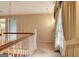 Upstairs hallway with carpet, view of front door with curtains, and stairway railing at 550 Hawthorne Dr, Fayetteville, GA 30214