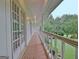 Long porch with white railings and columns offers a view of the lush lawn and mature trees at 550 Hawthorne Dr, Fayetteville, GA 30214