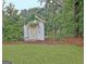 White outdoor shed with yellow trim and climbing plants, surrounded by grass and trees at 550 Hawthorne Dr, Fayetteville, GA 30214