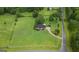 Aerial view of a charming home on a sprawling green lawn, surrounded by mature trees and a white fence at 10 Wigwam Cir, Whitesburg, GA 30185